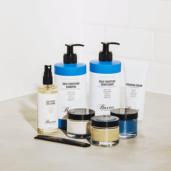 Assorted men's grooming products on a bathroom counter.